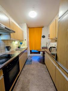 una cucina con mobili in legno e un tavolo al suo interno di Affordable room in Bremerhaven a Bremerhaven