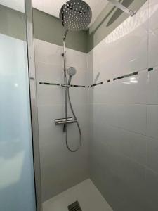 una ducha con cabezal de ducha en un baño en Appartement Souplex Centre de Cauterets, en Cauterets