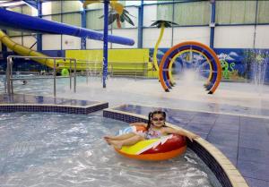 チャペル・セント・レオナルズにあるSkegness Retreats The Retreat 12a chapel st Leonards Golden Palm Resort skegnessのプールでいかだに乗っている女性