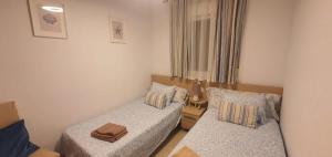 a small bedroom with two beds and a window at Casa Dorada Primera Línea Oropesa in El Borseral +41 photos