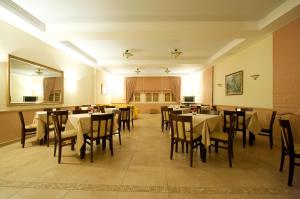 a restaurant with tables and chairs in a room at Hotel Oiti in Loutra Ipatis