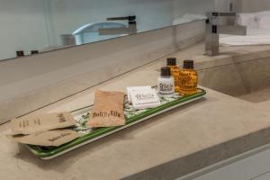 a tray with three bottles of alcohol on a counter at Scicli Albergo Diffuso in Scicli