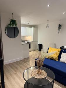 a living room with a blue couch and a table at Elegant 1 Bed Flat Near Stadium & Shops and free parking in Manchester +13 photos