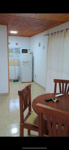 Un comedor con mesa y sillas y una cocina. en cabaña de montaña, en La Estancia