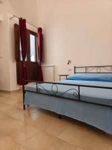 a bedroom with a bed with blue sheets and a window at Salento Corte 900 Neviano in Neviano