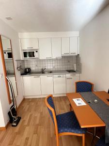 a kitchen with white cabinets and a table and chairs at Apart Jil-Marie Studio 7 in Samnaun