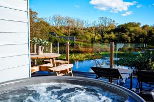 a hot tub on a patio with a table and chairs at Kingfisher in Pembrokeshire