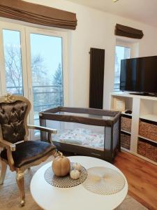 a living room with a crib and a table at APARTAMENT TATARSKA in Przemyśl