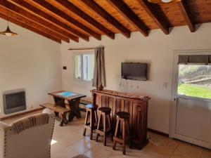 a living room with a table and stools at La Tranquera - Cabaña Cálida y Versátil in Trevelín