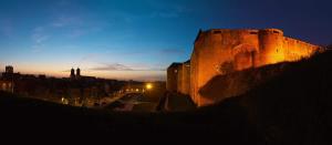 un gran castillo iluminado por la noche en Appartement Chic - Parking Prive, en Charleville-Mézières
