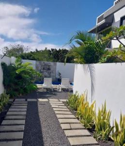 un jardín con 2 sillas y una valla en Marbella villas 2, en Grand Baie