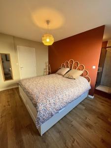 a bedroom with a bed with a orange wall at Maison 3 chambres in Changé