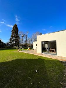 a building with a large window and a green yard at Maison 3 chambres in Changé