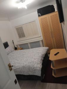 a small bedroom with a bed and a window at Cullen Sqaure in South Ockendon