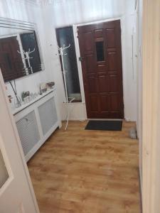 a hallway with a wooden floor and a door at Cullen Sqaure in South Ockendon