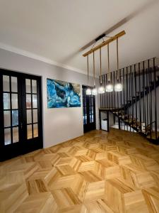 a room with a wooden floor and a staircase at Nest Stay in Tbilisi City