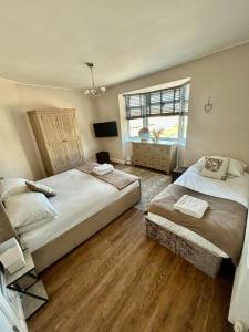 a bedroom with two beds and a window at Denzels Den Apartment 2 in Llandudno Junction
