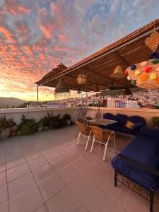 Un patio con una mesa y sillas en un tejado. en Casa Abdou, en Chefchaouen