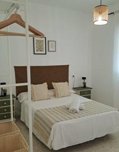 a bedroom with a white bed with a wooden frame at LabellaCasona in Quéntar +35 photos