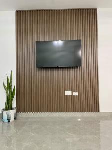 にあるTcs Homes at The Vineyardsの植物の壁に薄型テレビが付いています。
