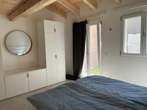 ContraにあるGuest House 6646のベッドと鏡と窓のある寝室