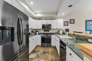 a kitchen with white cabinets and stainless steel appliances at Cozy Breck Condo - Walk to Main St & Lifts - Hot Tub in Breckenridge