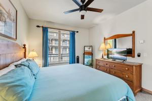 a bedroom with a bed and a dresser with a mirror at Cozy Breck Condo - Walk to Main St & Lifts - Hot Tub in Breckenridge
