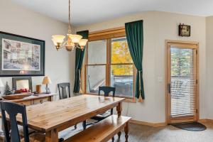 a dining room with a wooden table and a window at Cozy Breck Condo - Walk to Main St & Lifts - Hot Tub in Breckenridge +24 photos