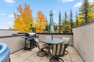 a patio with a grill and a table and chairs at Cozy Breck Condo - Walk to Main St & Lifts - Hot Tub in Breckenridge