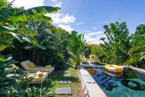 a backyard with a swimming pool and chairs and a swimming pool at Villa 1493 in Anse des Cayes