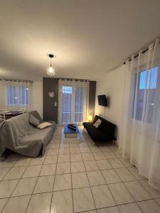 a living room with a couch and a table at CNPE Bugey 10 MN - Aéroport LYS 18 MN in Pont-de-Chéruy