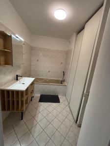 a bathroom with a sink and a bath tub at CNPE Bugey 10 MN - Aéroport LYS 18 MN in Pont-de-Chéruy