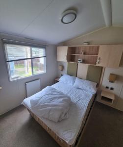 a bedroom with a large white bed with a window at 158 Unity Beach Brean 4 birth No pets sorry in Berrow