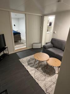 een woonkamer met een bank en twee tafels bij Tromsø Stay in Tromsø