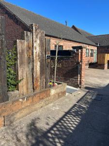 a brick building with a wooden fence in front of it at The Bungalow in Lichfield