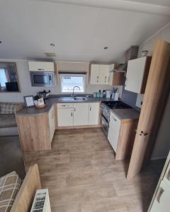 a small kitchen with white cabinets and a sink at 158 Unity Beach Brean 4 birth No pets sorry in Berrow