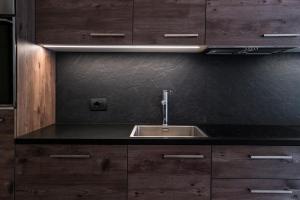 a kitchen with a sink and wooden cabinets at Dolomites Chalet Niuasi in Ortisei +80 photos