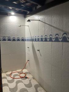 a bathroom with a red hose on a tiled wall at Apartamento Pé na Areia- Torres in Torres