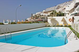 a swimming pool on the side of a building at Apartamentos Gelimar in Puerto Rico de Gran Canaria