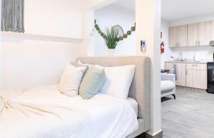 a bedroom with a bed with white sheets and pillows at AQUA Terrazas Studio 3 - Beachfront, Pool, Local Fun & Dining in Dorado +10 photos