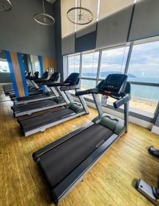 eine Reihe von Laufbändern in einem Fitnessraum mit Fenstern in der Unterkunft Moderno Flat no Gonzaga na quadra da Praia in Santos + 11 Fotos