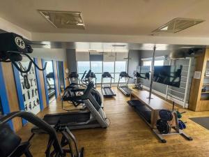 einen Fitnessraum mit Laufbändern und einem Flachbild-TV in der Unterkunft Moderno Flat no Gonzaga na quadra da Praia in Santos