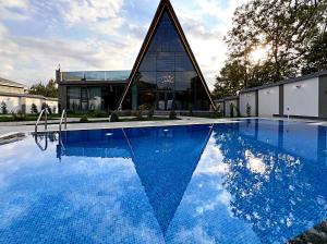 a house with a swimming pool in front of a building at Qafqaz Palm A-Frame Retreat in Gabala
