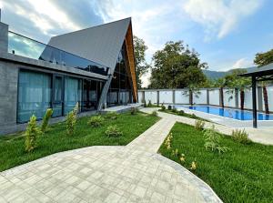 a house with a walkway in front of a building at Qafqaz Palm A-Frame Retreat in Gabala