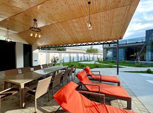 a patio with a table and chairs with orange cushions at Qafqaz Palm A-Frame Retreat in Gabala