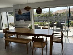 ブルティニョール・シュル・メールにあるVilla avec jacuzzi proche de la plage, vélo à dispositionの木製のテーブルと椅子のあるダイニングルーム