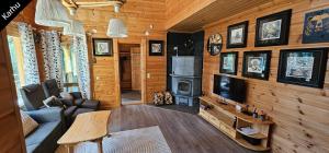 un soggiorno con divano e TV in una cabina di Quiet Lakeside Forest Escape a Virasoja