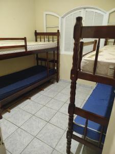 two bunk beds in a room with a tiled floor at Perequê Açu beach house in Ubatuba