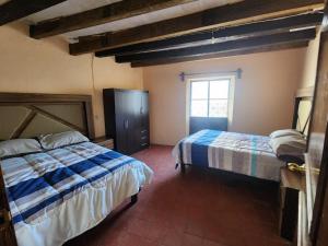 a bedroom with two beds and a window at Camino Santa Prisca in Taxco de Alarcón