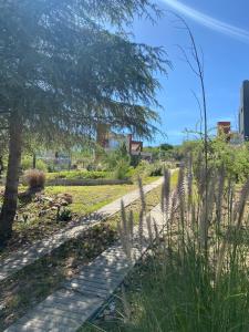 a path in a park with a tree and grass at Altos del Oeste in Villa Carlos Paz